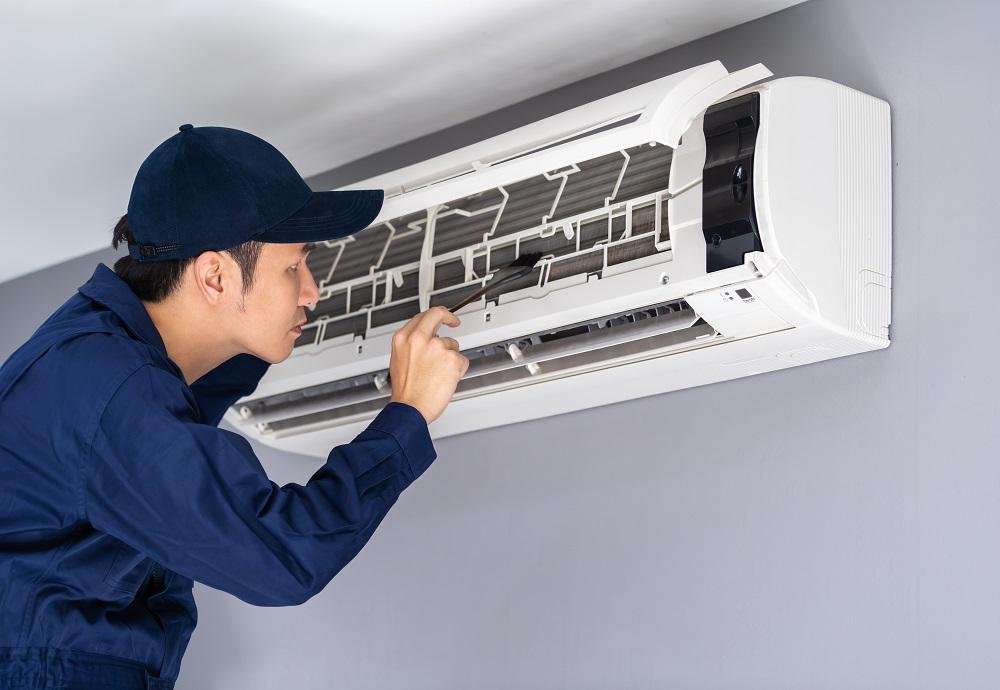Technician servicing a home air conditioner