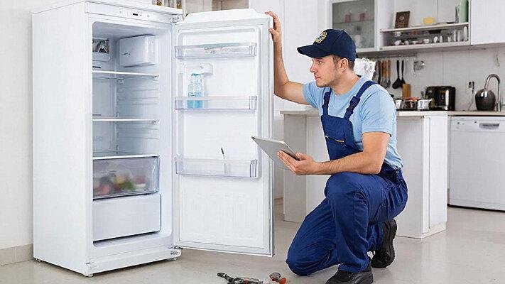 Technician repairing a refrigerator compressor